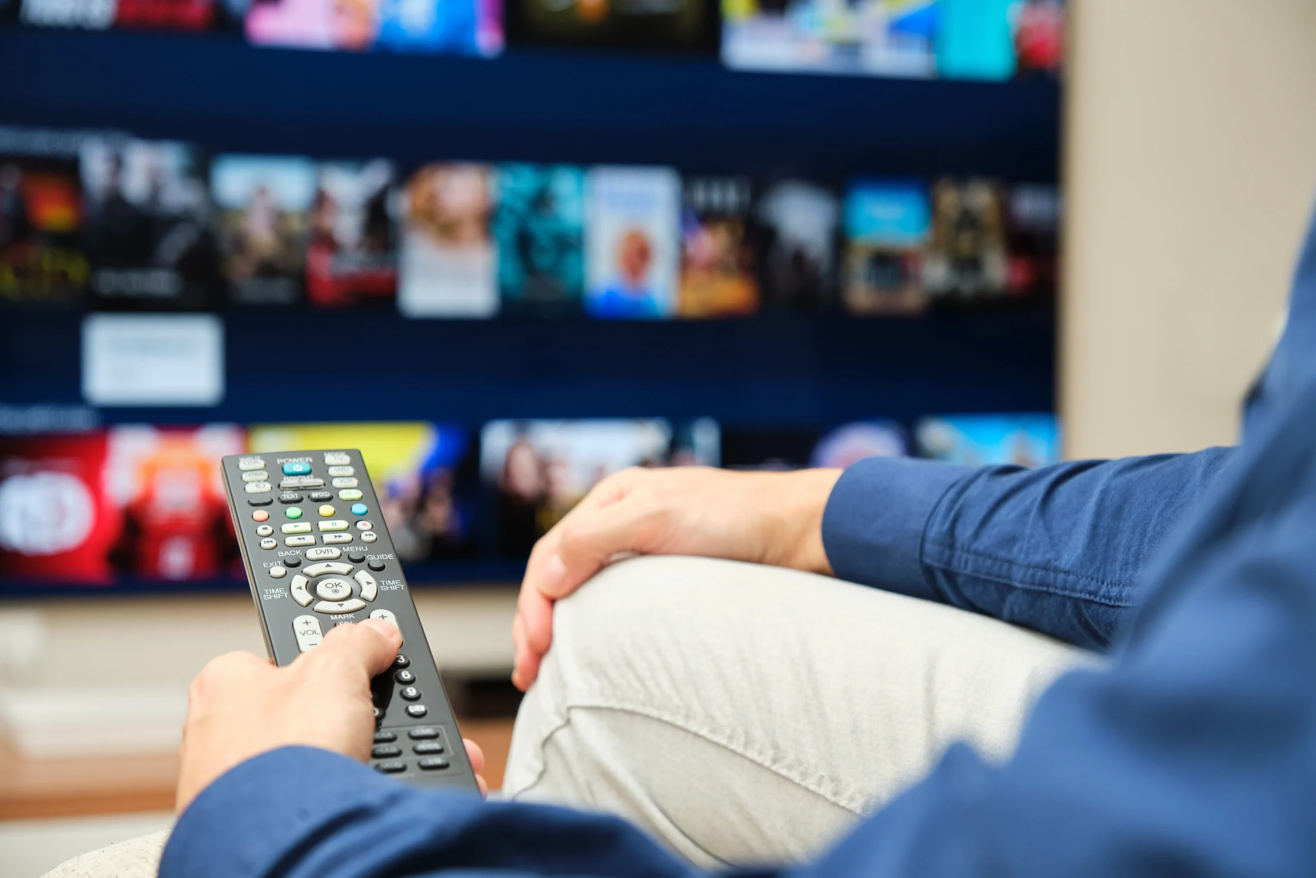 Člověk ovladačem míří na TV.