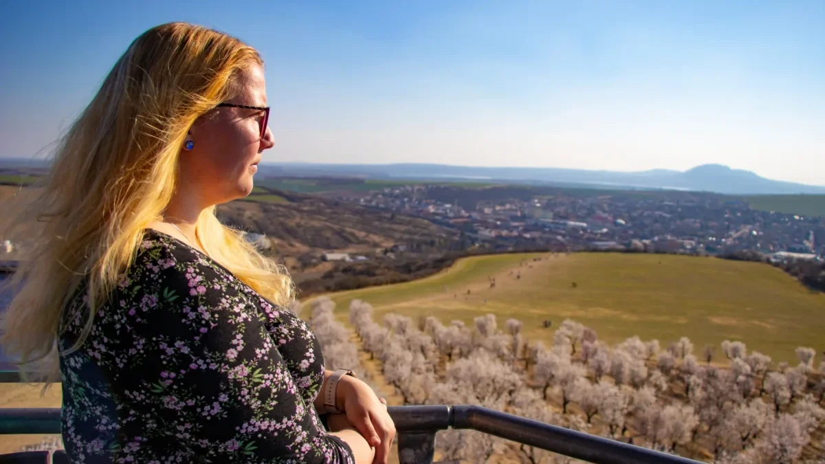 Blonďatá žena pozoruje výhled.