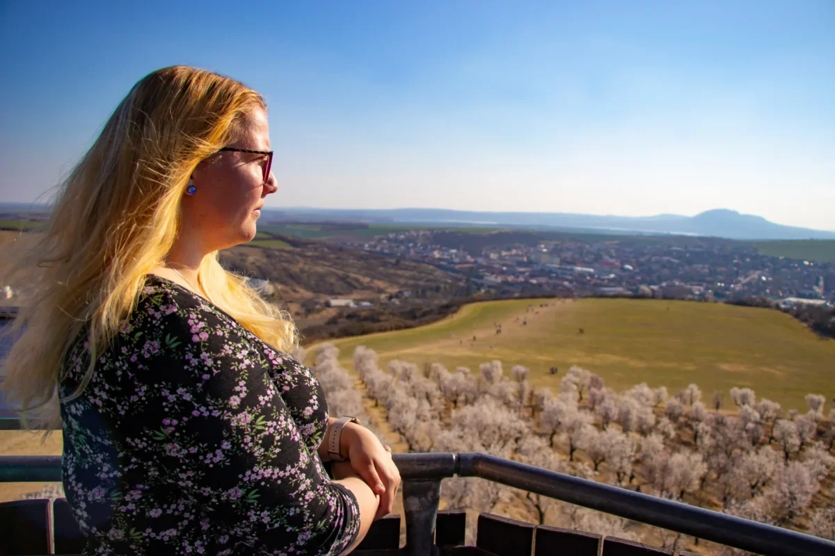 Blonďatá žena pozoruje výhled.