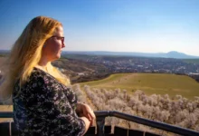 Blonďatá žena pozoruje výhled.
