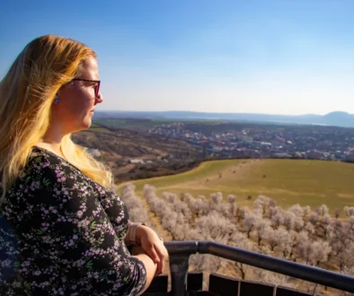 Blonďatá žena pozoruje výhled.