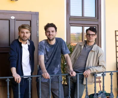 tři mladí muži na pavlači