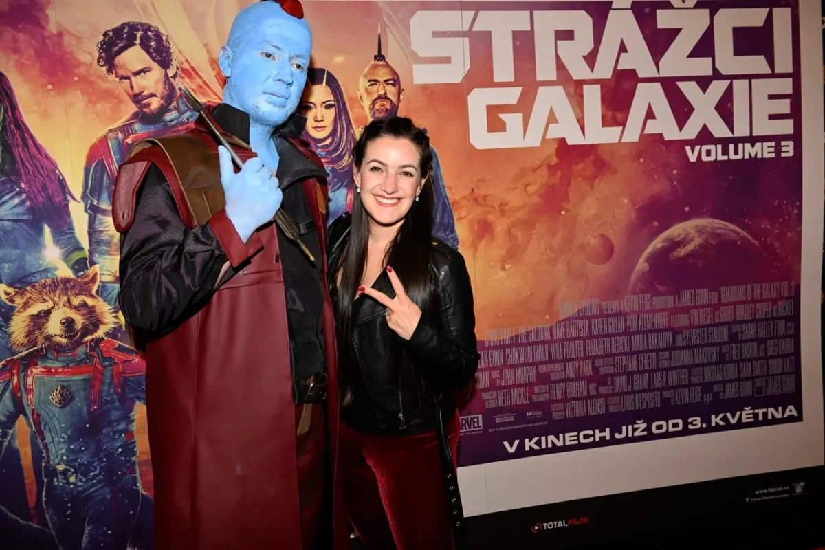 Strážci galaxie v kině | TVGURU.cz Woman wearing black leather jacket smiles and poses with a blue-skinned cosplayer in a red cape in front of a Guardians of the Galaxy poster.