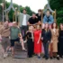 Group of adults posing on a colorful playground structure outdoors in a park.
