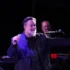 herec russell crowe ve smokingu mluvící do mikrofonu na podiu
