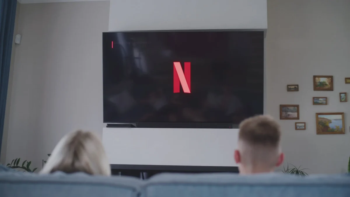 Obývajíc pokoj s televizí, na které je logo Netflixu.