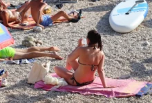 Žena sedí na ručníku.