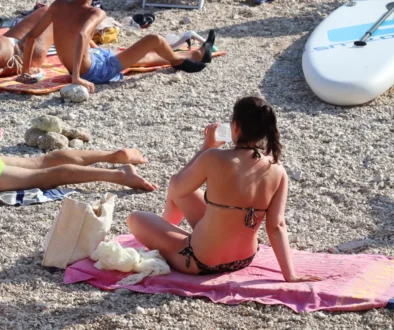 Žena sedí na ručníku.