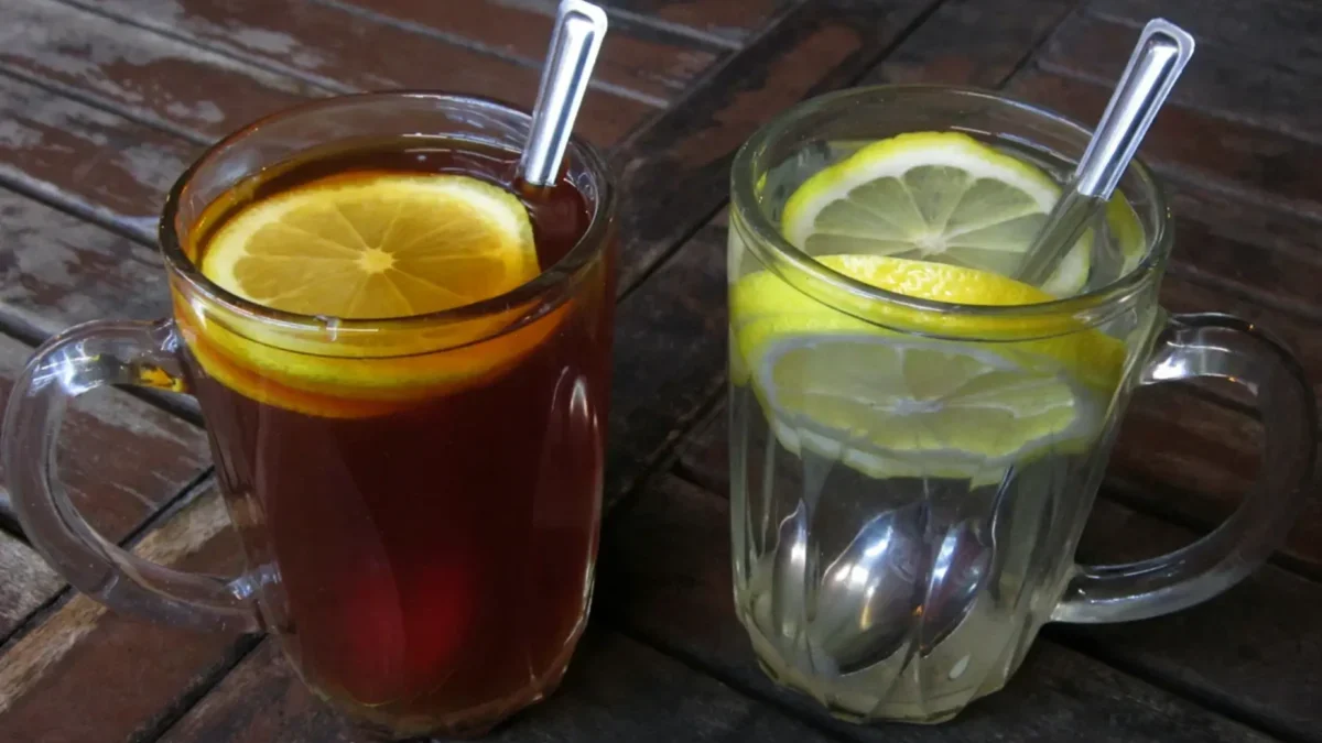 Na stole stojí hrnky s vodou a kávou