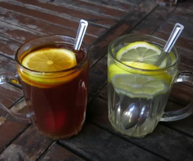 Na stole stojí hrnky s vodou a kávou