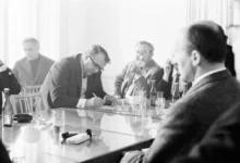 Jan Werich s dalšími lidmi sedí u stolu.
