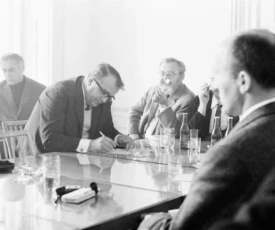 Jan Werich s dalšími lidmi sedí u stolu.