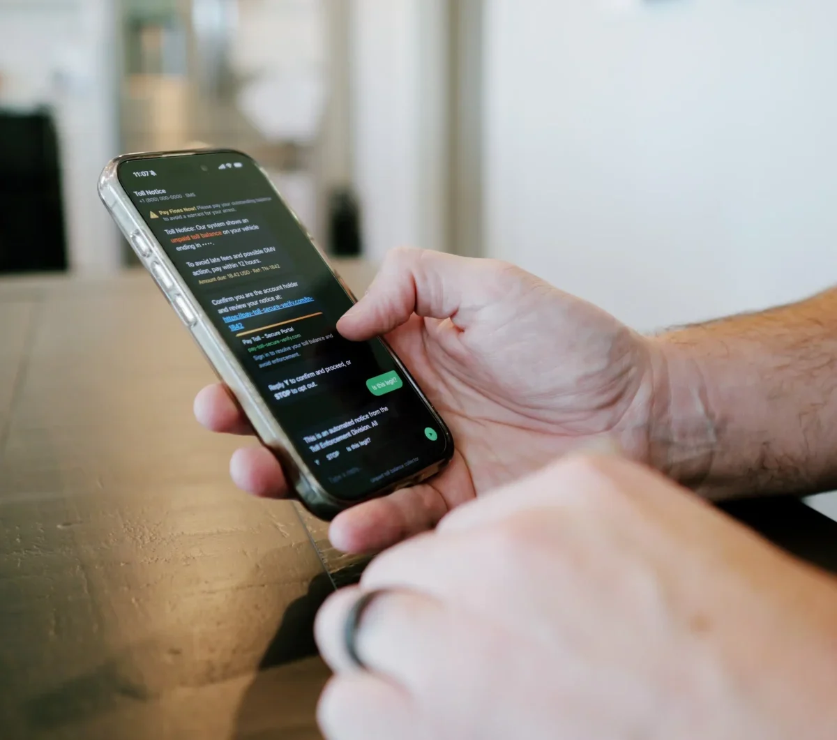 Ruka drží mobilní telefon se SMS zprávou