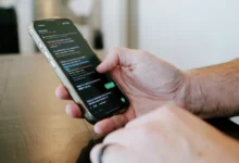 Ruka drží mobilní telefon se SMS zprávou