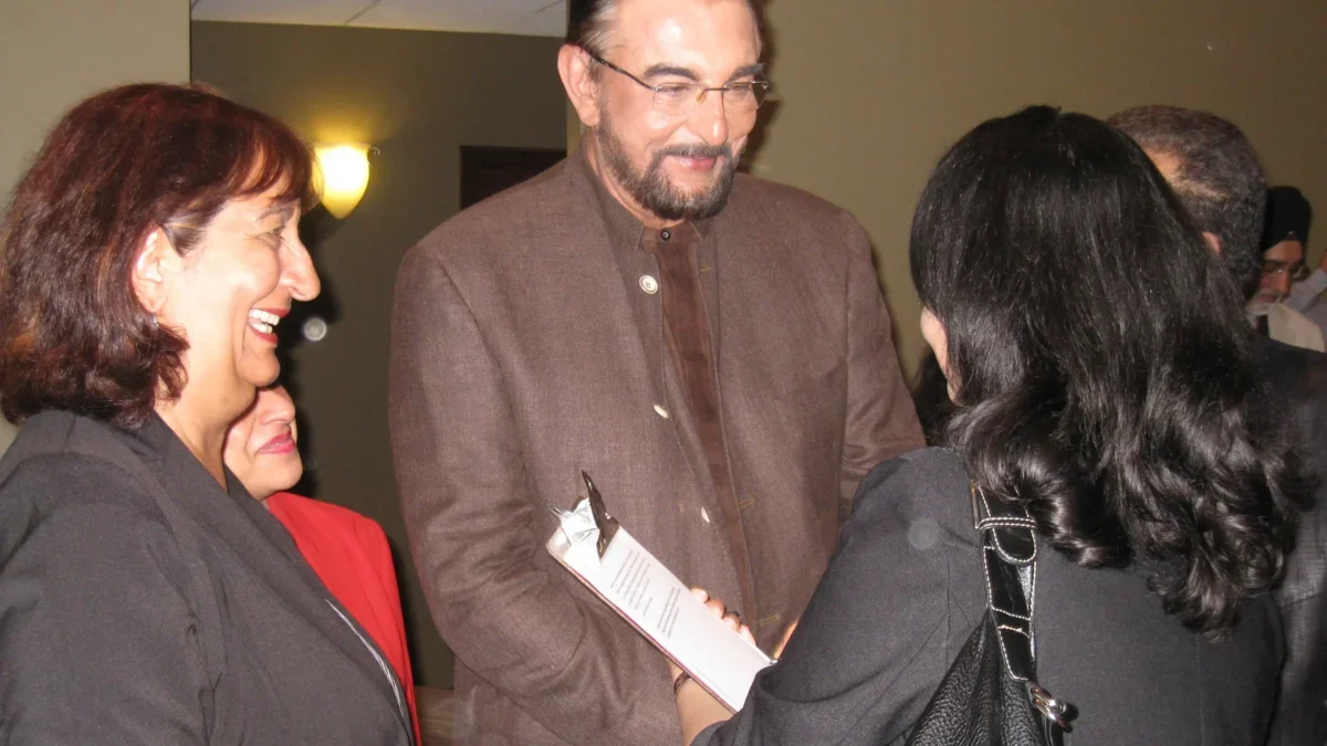 Kabir Bedi třese rukou paní.