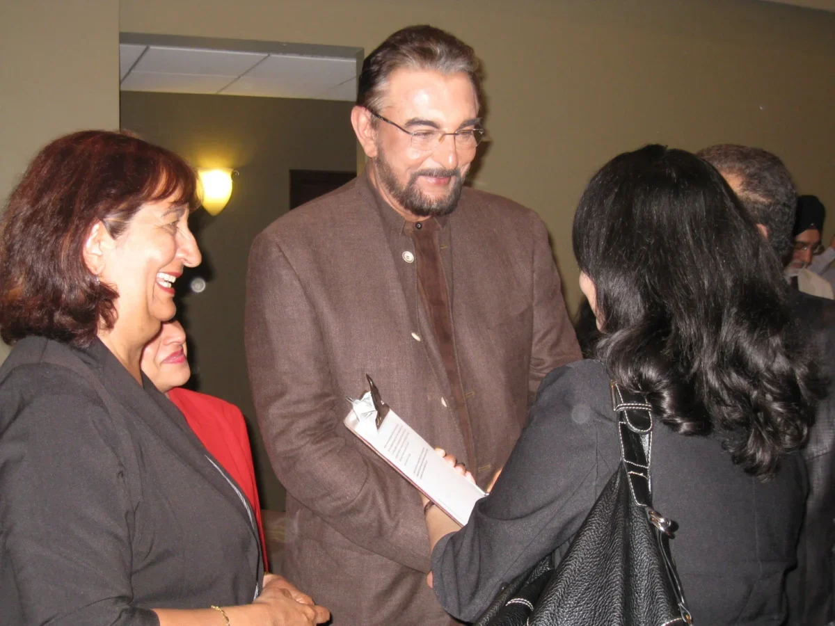 Kabir Bedi třese rukou paní.