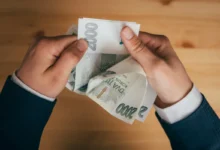 Muž držící v rukách české dvoutisícové bankovky