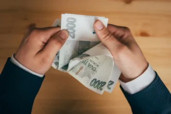 Muž držící v rukách české dvoutisícové bankovky