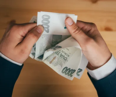 Muž držící v rukách české dvoutisícové bankovky