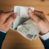 Muž držící v rukách české dvoutisícové bankovky