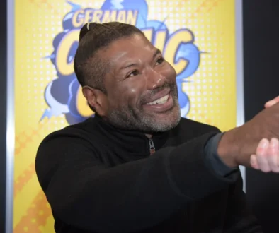 Christopher Judge si s někým třese rukou.