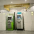 ATM machines line a modern wall inside a bank, with a sign reading 'BANKOMATY | ATM ZONE' overhead