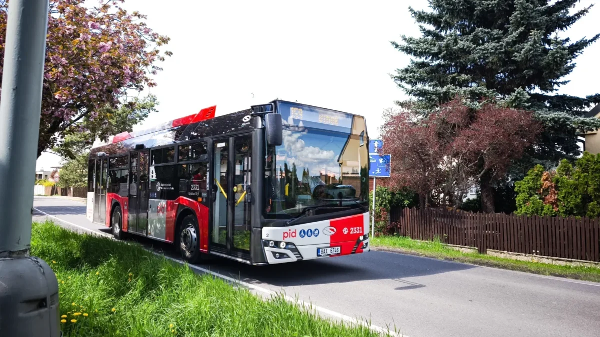 Pražský autobus jede po silnici.