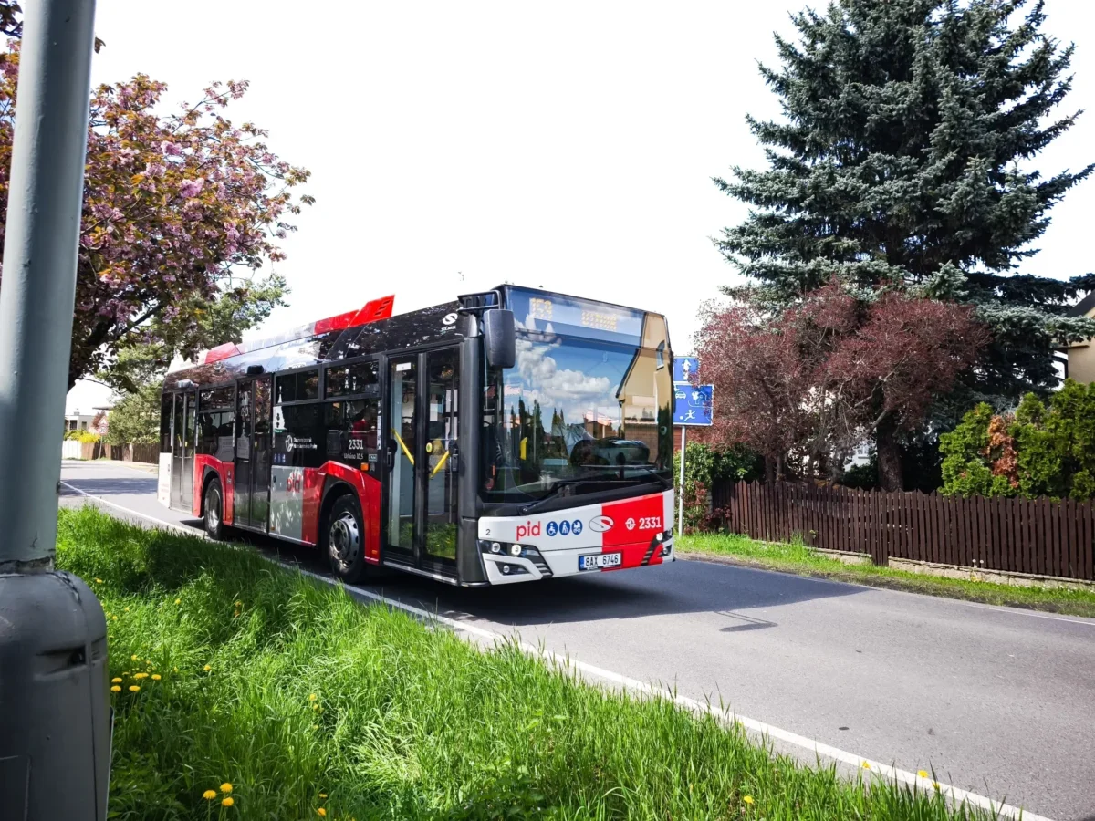 Pražský autobus jede po silnici.