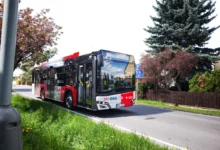Pražský autobus jede po silnici.