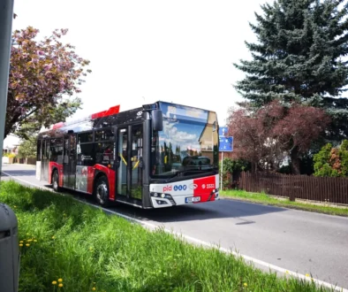 Pražský autobus jede po silnici.