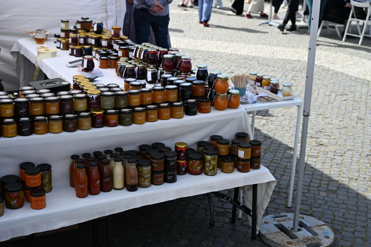 shutterstock_2775259773 1 | TVGURU.cz Table full of assorted jars of jam and preserves at an outdoor market stall