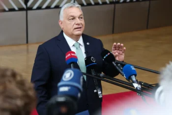 Maďarský politik mluví do mikrofonu.