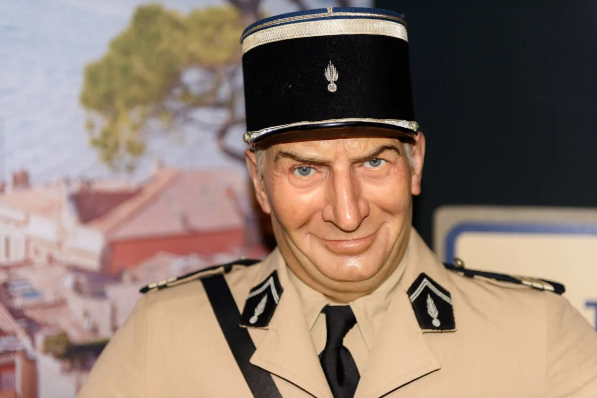 Četník ze Saint-Tropez je hercovou nejslavnější rolí. Zdroj: Shutterstock | TVGURU.cz Close-up of a person in a beige military-style uniform and black peaked cap with a silver emblem, facing the camera.
