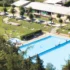 Koupaliště skládající se z bazénu a travnatí plochy.