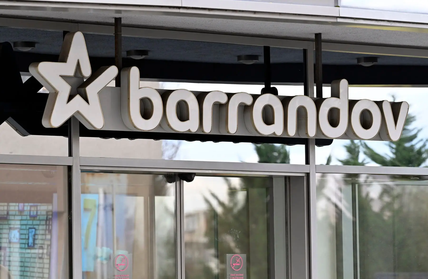Storefront sign showing the word 'barandov' with a large star logo on the left, mounted above glass doors.