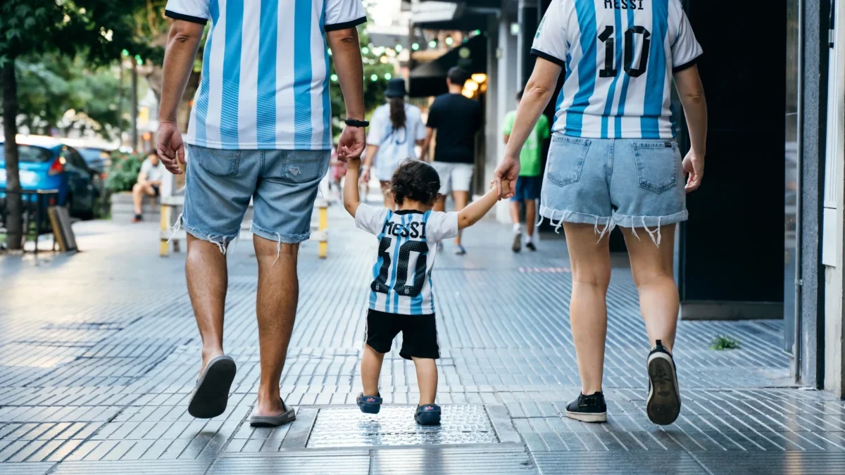 Rodina oblečená v argentinských dresech se prochází městem.