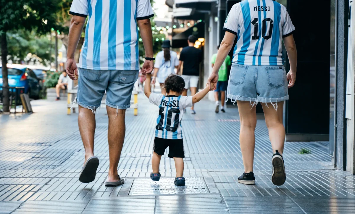 Rodina oblečená v argentinských dresech se prochází městem.