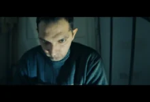Muž sedí ve tmě.