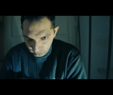 Muž sedí ve tmě.