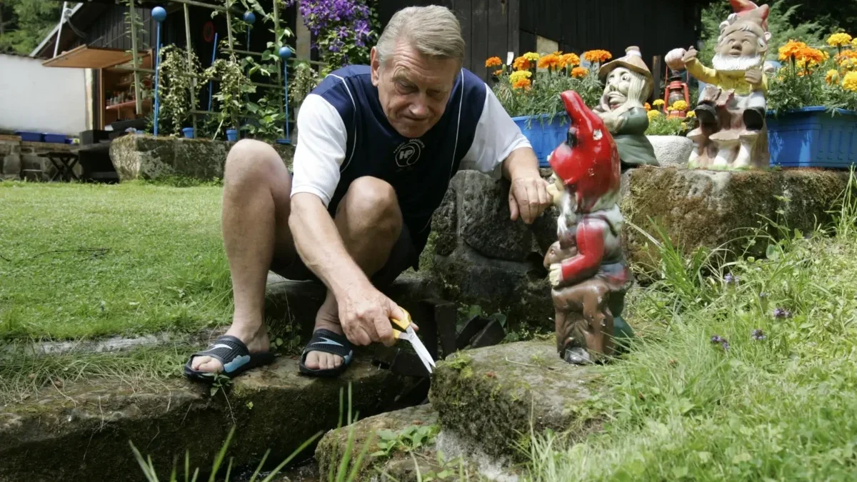 Josef Dvořák klečí vedle trpaslíka.