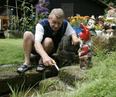 Josef Dvořák klečí vedle trpaslíka.