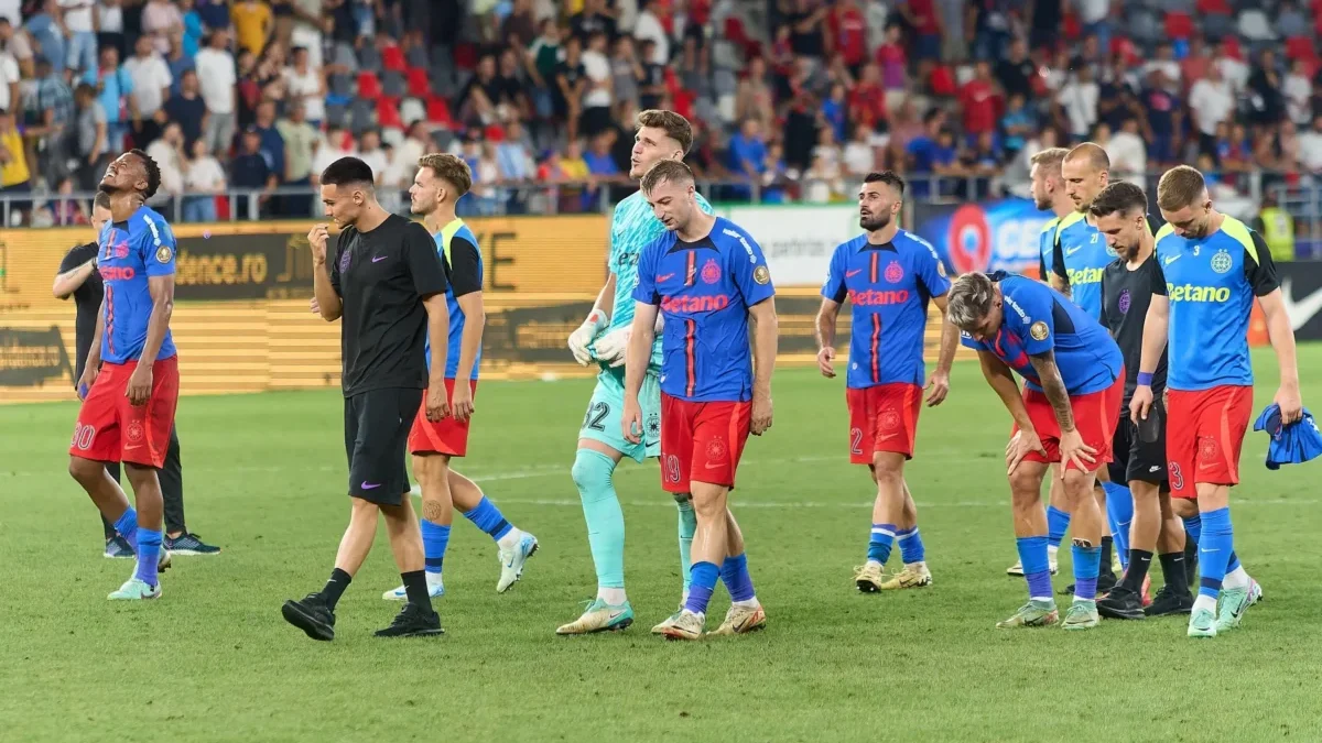 Fotbalisté jdou po hřišti.