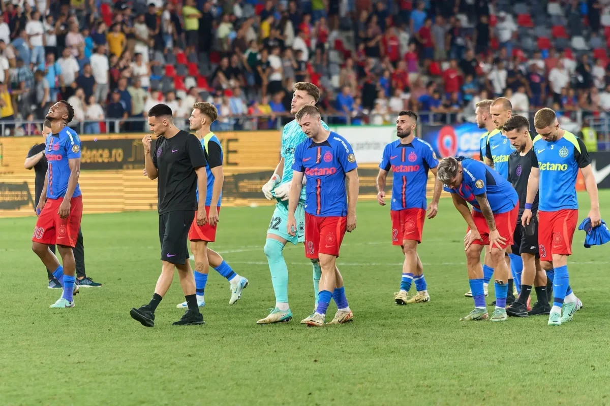 Fotbalisté jdou po hřišti.