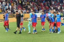 Fotbalisté jdou po hřišti.