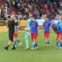 Fotbalisté jdou po hřišti.