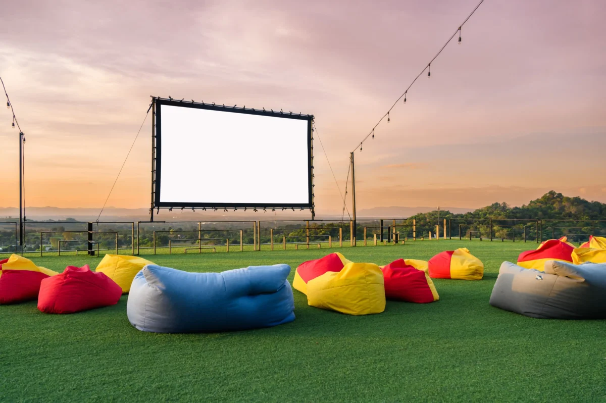 Letní kino s barevnými polštáři na trávě