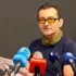 muž v brýlích s mikrofony před sebou