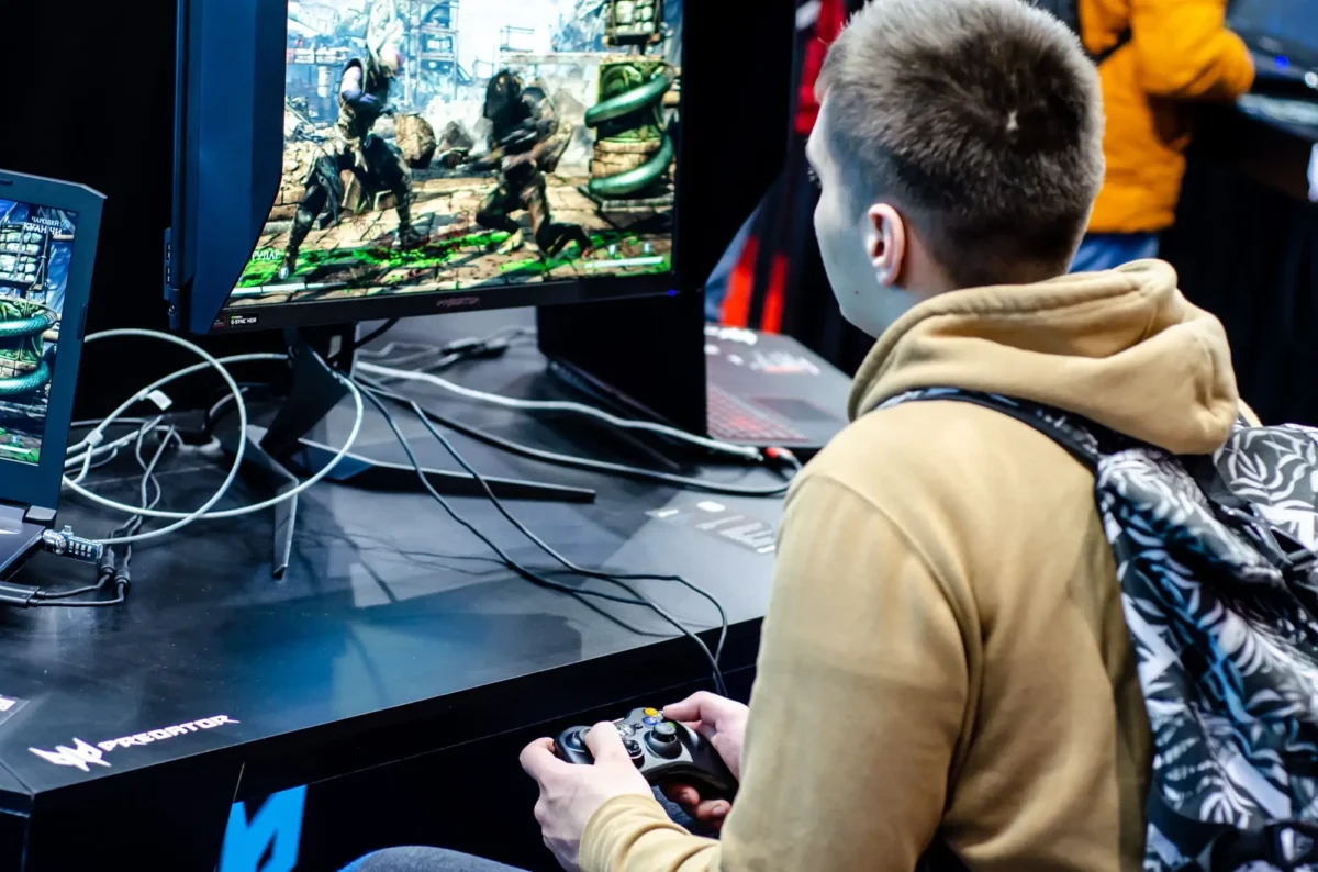 mladý kluk hraje mortal kombat na počítači