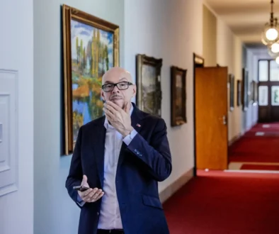 muž v brýlích s mobilem v ruce