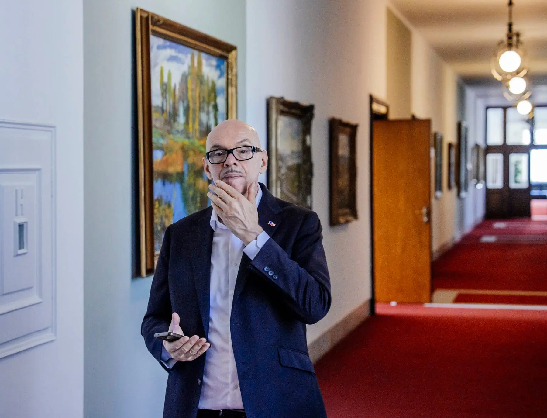 muž v brýlích s mobilem v ruce